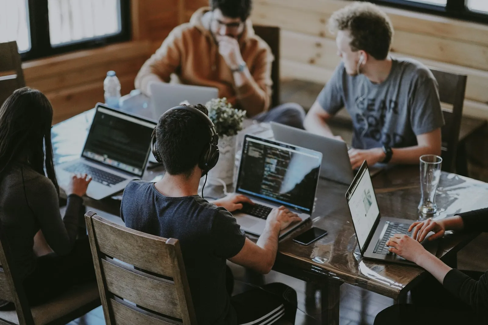 Distributed team working on laptops around a shared table